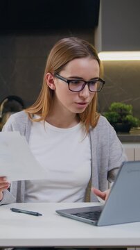 Caucasian businesswoman working with papers in home office woman read loan invoice document ,freelancer accountant pay bills, credit, taxes online on laptop count finances. Slow motion