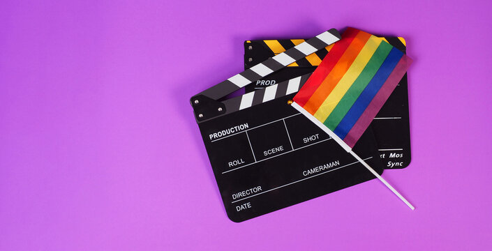 Two Clapper board and rainbow pride flag on purple or violet background.