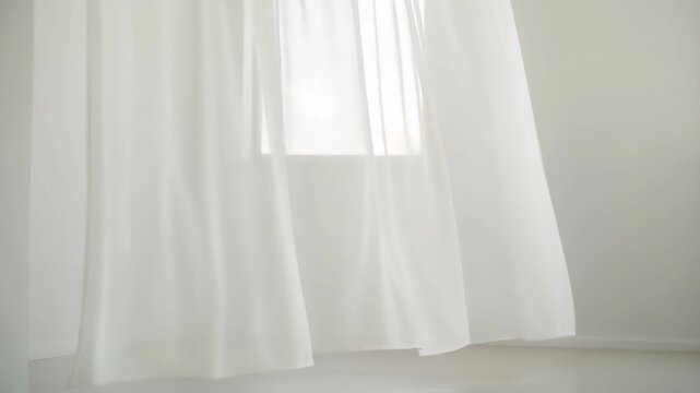Static shot of sheer white curtain gently blowing in breeze near bright window indoors