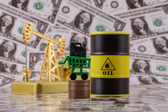 A gasoline can and a gold oil pump against a backdrop of a $1 bills