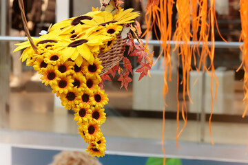 Obraz premium Bright yellow sunflowers cascade from a woven basket in a decorative indoor display