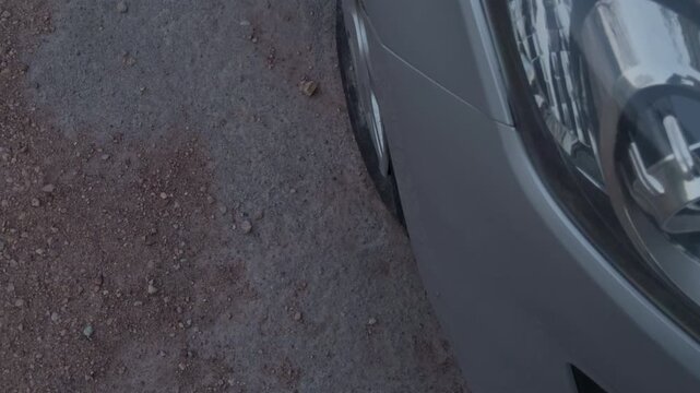 Highdetail image capturing car headlight and textured environment. Specialized closeup showcasing vehicle lighting with reflective surfaces and industrial aesthetics for media use