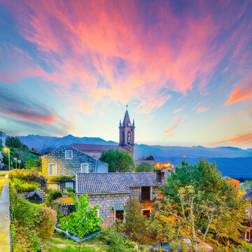 Amazing evening cityscape with Parish Church of the Assumption in Zonza village with typical stone houses