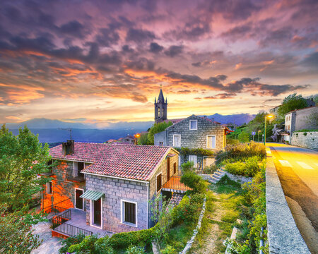 Amazing evening cityscape with Parish Church of the Assumption in Zonza village with typical stone houses