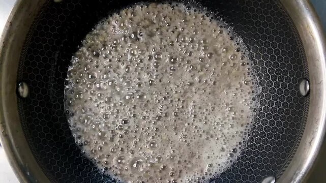 Cumin seeds frying in hot oil top view Indian cooking close up 4k with natural sizzling sound