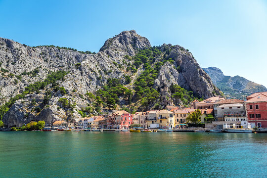 Scenic view of Omis coastal town and Cetina river canyon at the foot of massive limestone cliffs in Dalmatia, Croatia