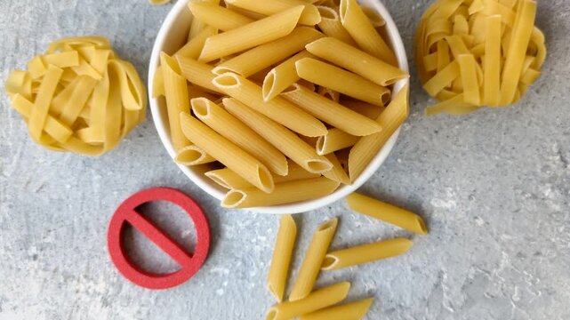 Italian uncooked dry penne regatta pasta with a gluten prohibition sign. The gluten prohibition sign as a background for your design.