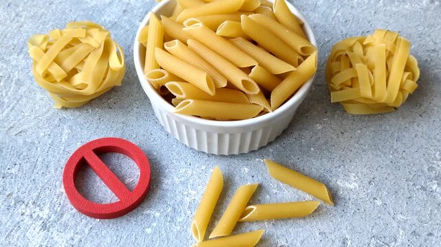 Italian uncooked dry penne regatta pasta with a gluten prohibition sign. The gluten prohibition sign as a background for your design.