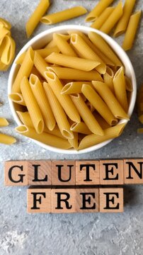 Italian uncooked, dry, gluten free penne regate pasta, ready for cooking. Dry, gluten free penne pasta as a food background for your design