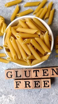 Italian uncooked, dry, gluten free penne regate pasta, ready for cooking. Dry, gluten free penne pasta as a food background for your design