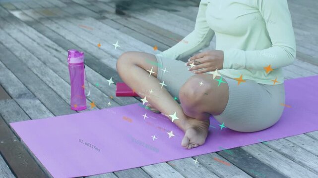 Woman lowering pink notebook and starting meditation on purple mat, adjusting legs, stars moving