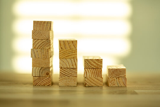 Wooden blocks are arranged in a bar graph formation showing a decrease over time.