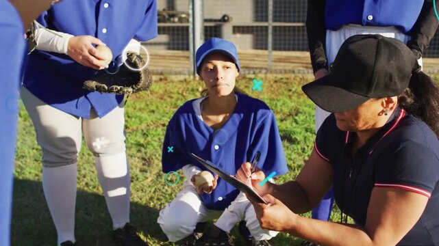 Coach checking clipboard and marking notes, players passing baseball and adjusting gloves pre-game