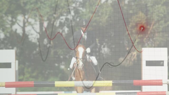 Male rider nearing rail clearing jump in equestrian meet, overlay tracking horse with red hotspot
