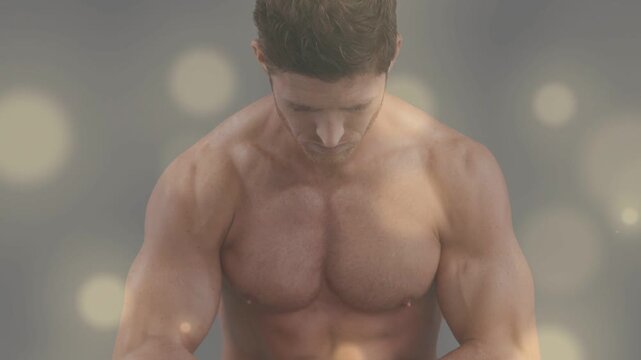 Man starting bowed head, camera widening, lifting arms, flexing chest with warm bokeh for fitness