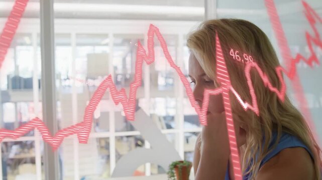 Female analyst watching red finance graph animating on glass wall, shifting gaze, analyzing trends