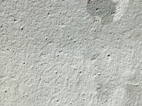 Textura de muro con estuco gris y zona de pintura descascarada sobre superficie rugosa