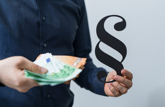Business man holds Euro banknotes with a paragraph symbol, representing finance, legal issues and su