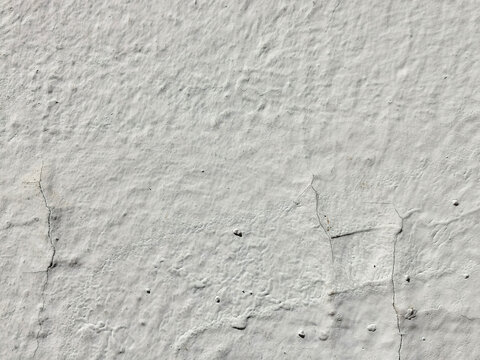 Textura de muro con estuco blanco envejecido y grietas sutiles en la superficie