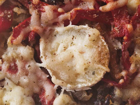 Primer plano de pizza reci&eacute;n horneada con rodaja de queso de cabra y tomate