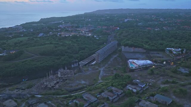 Abandoned hotel construction site near bali coastline at sunset