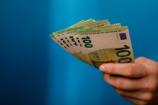 Hand holding Euro currency. Concept of finance, wealth, business and money saving on a bl