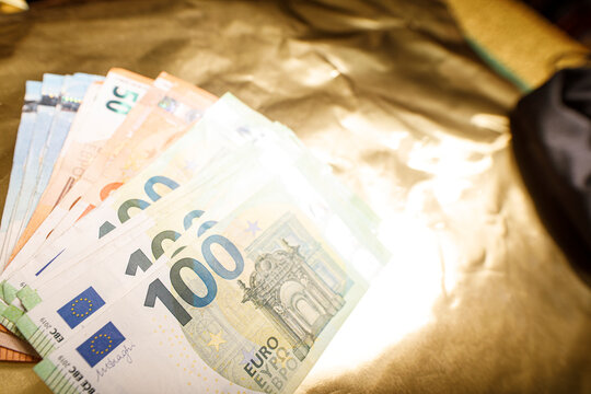 Close up of Euro banknotes fanned out on gold fabric, representing finance, wealth, inves