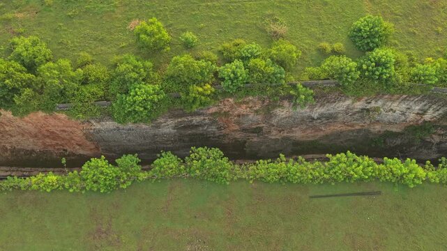 Aerial top down view of Tanah barak road through rocky cliff in bali