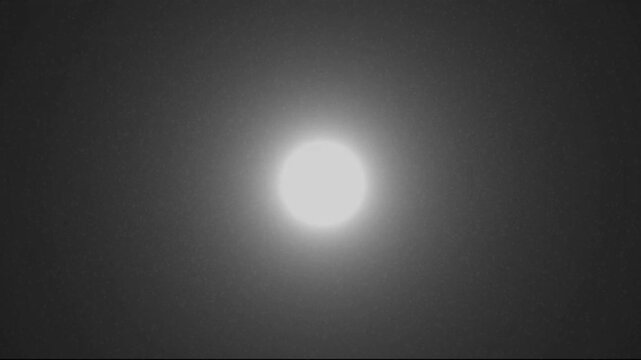 Dark abstract background with a subtle speckled texture and faint geometric shapes at the bottom edge against a deep black void creating a minimalist and enigmatic visual