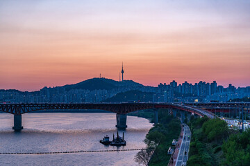 Obraz premium Seoul, South Korea - Apr. 24, 2026 : Sunset Cityscape of Seoul with N Seoul Tower, Seongsu Bridge and Busy Traffic on Gangbyeonbukro Highway