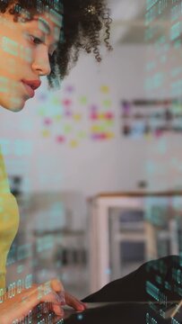 Vertical video: Woman typing on laptop at tech desk, pausing then resuming coding with code overlay