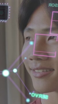Vertical video: Male teen looking up smiling, AR HUD appearing, boxes aligning over eyes for tech