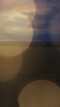 Vertical video: Horizon and storm clouds staying while drifting bokeh revealing thin bright line