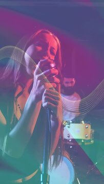 Vertical video: Lead singer gripping mic and singing, band starting music, waveforms sweeping stage