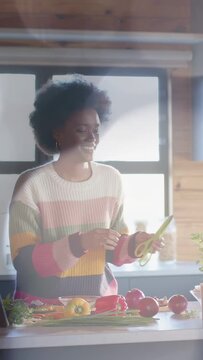 Vertical video: Woman reaching for green peeler, trimming greens on kitchen counter, preparing meal