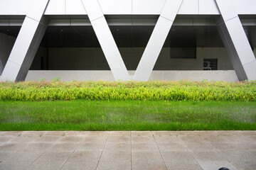 Naklejka premium Modern architectural geometric structure with green landscaping and clean lines