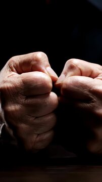 Close up shot of a man's hands aggressively clenching into tight, shaking fists, knuckles turning white from intense anger and psychological frustration, harsh high-contrast moody lighting, 4k.