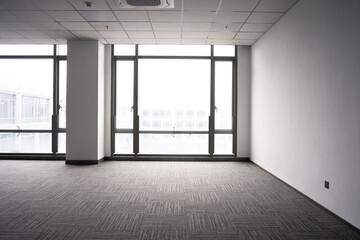Naklejka premium Spacious modern office interior with floor-to-ceiling windows and minimalist design