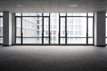 Empty office space with floor-to-ceiling windows overlooking urban high-rise buildings © zhu difeng