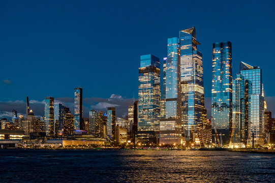 Wide view of Hudson Yards skyline and Vessel at night. Panoramic night shot of Manhattan west side with illuminated Vessel and Hudson Yards modern skyscrapers.