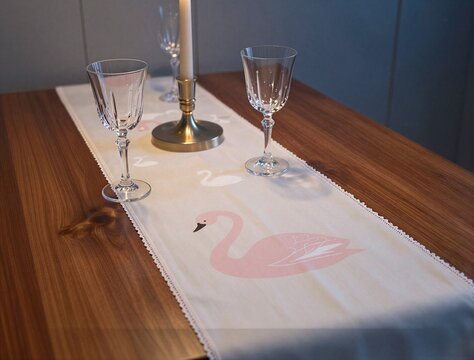 Pink swan table runner set with glassware on wooden table