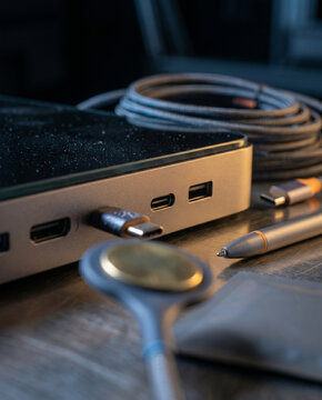 A vertical portrait capturing the precise moment an electrode connector approaches a port on the milled aluminum Rehab Hub, bathed in high-contrast mixed lighting.