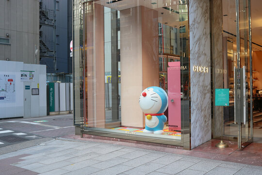 TOKYO, JAPAN - February 3, 2021: Gucci store window display in Tokyo's Ginza area featuring the character Doraemon. There is a construction site opposite the store.