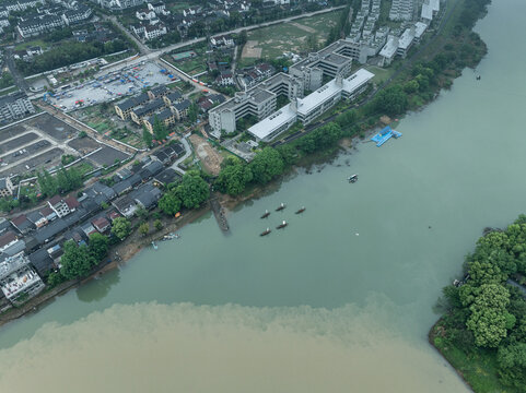 Aerial view of riverside ancient town with school buildings and surrounding landscape