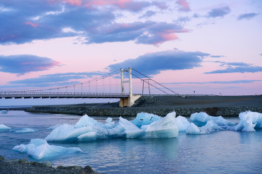 Scenic view of Jokulsarlon Glacier Lagoon with floating icebergs and suspension bridge in Iceland