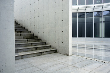 Naklejka premium Concrete staircase adjacent to glass curtain wall in a modern architectural setting