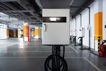 Naklejka premium Electric vehicle charging station in an underground parking garage with modern infrastructure