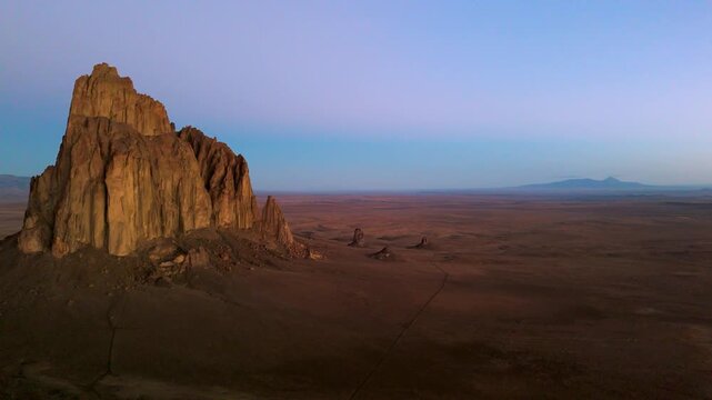 Aerial video of Shiprock, New Mexico at sunset with Sleeping Ute mountain in the background.