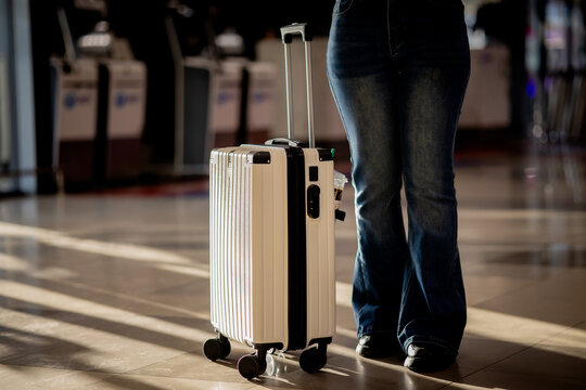 Smiling traveler walking through airport with suitcase, ready for holiday adventure and sightseeing journey, capturing excitement, freedom, and modern travel lifestyle.
