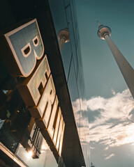 Illuminated Berlin sign and Fernsehturm TV Tower with glass facade reflection, low angle view at Alexanderplatz © BERLIN-BELICHTET.DE